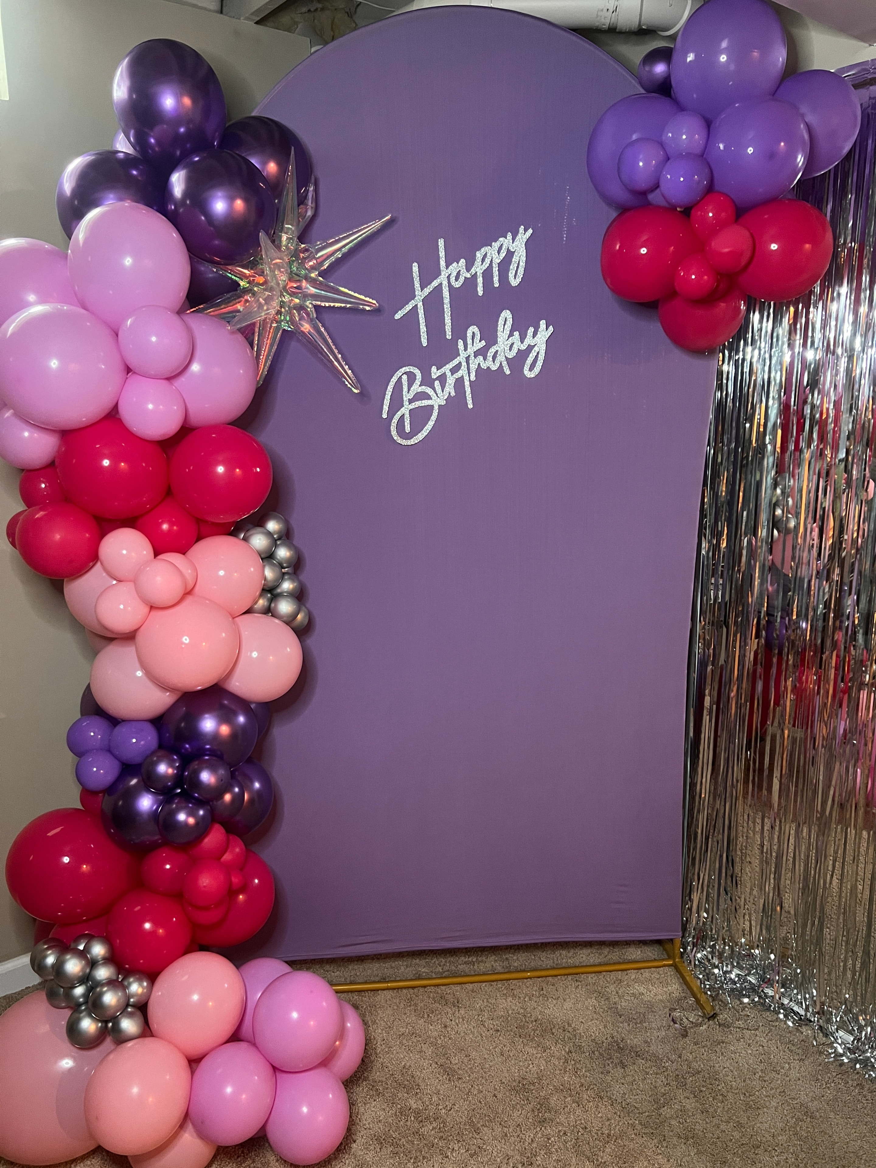 Purple Happy Birthday backdrop with pink and red balloon garland