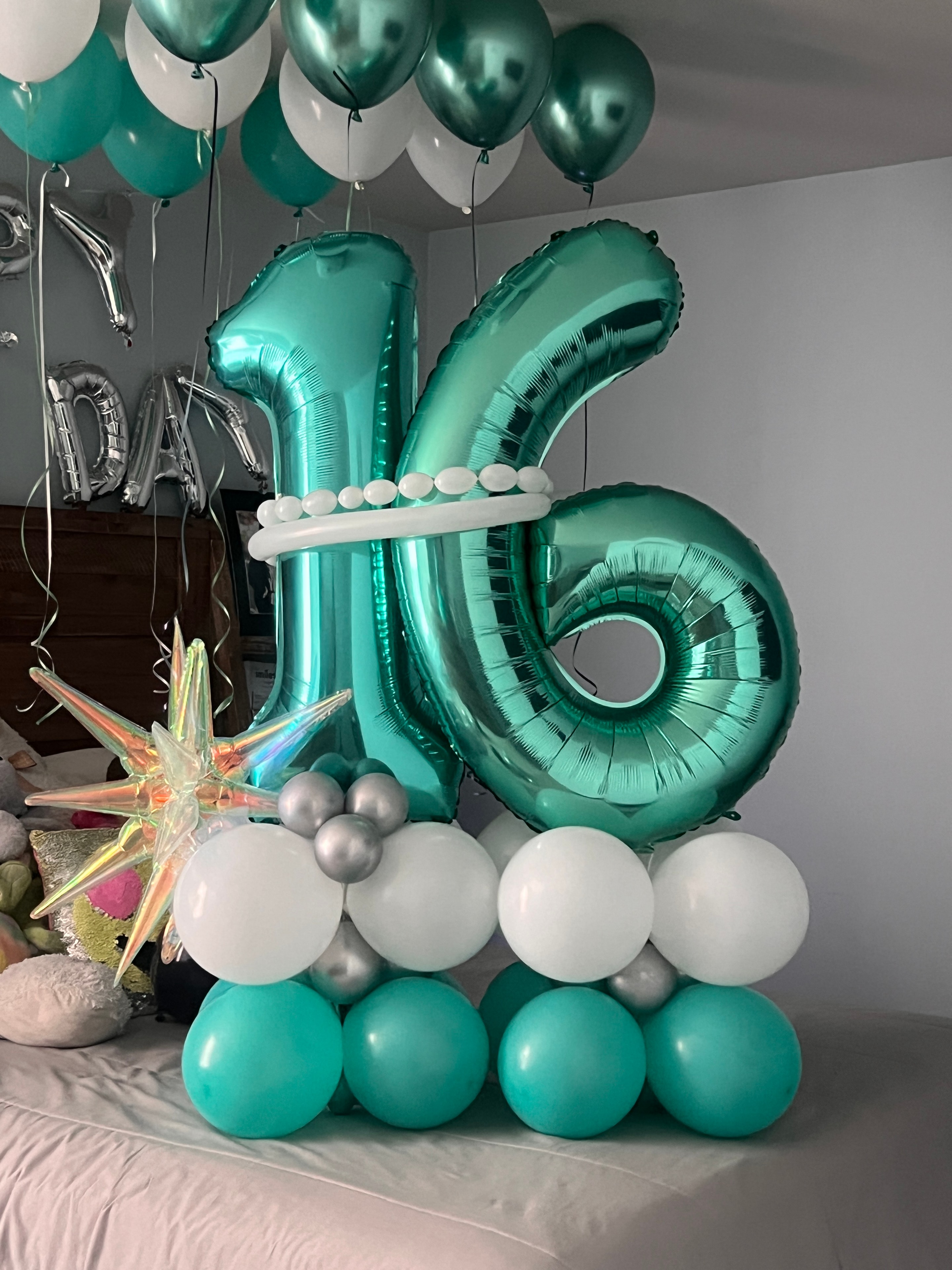 Teal and white number balloon display with star accent