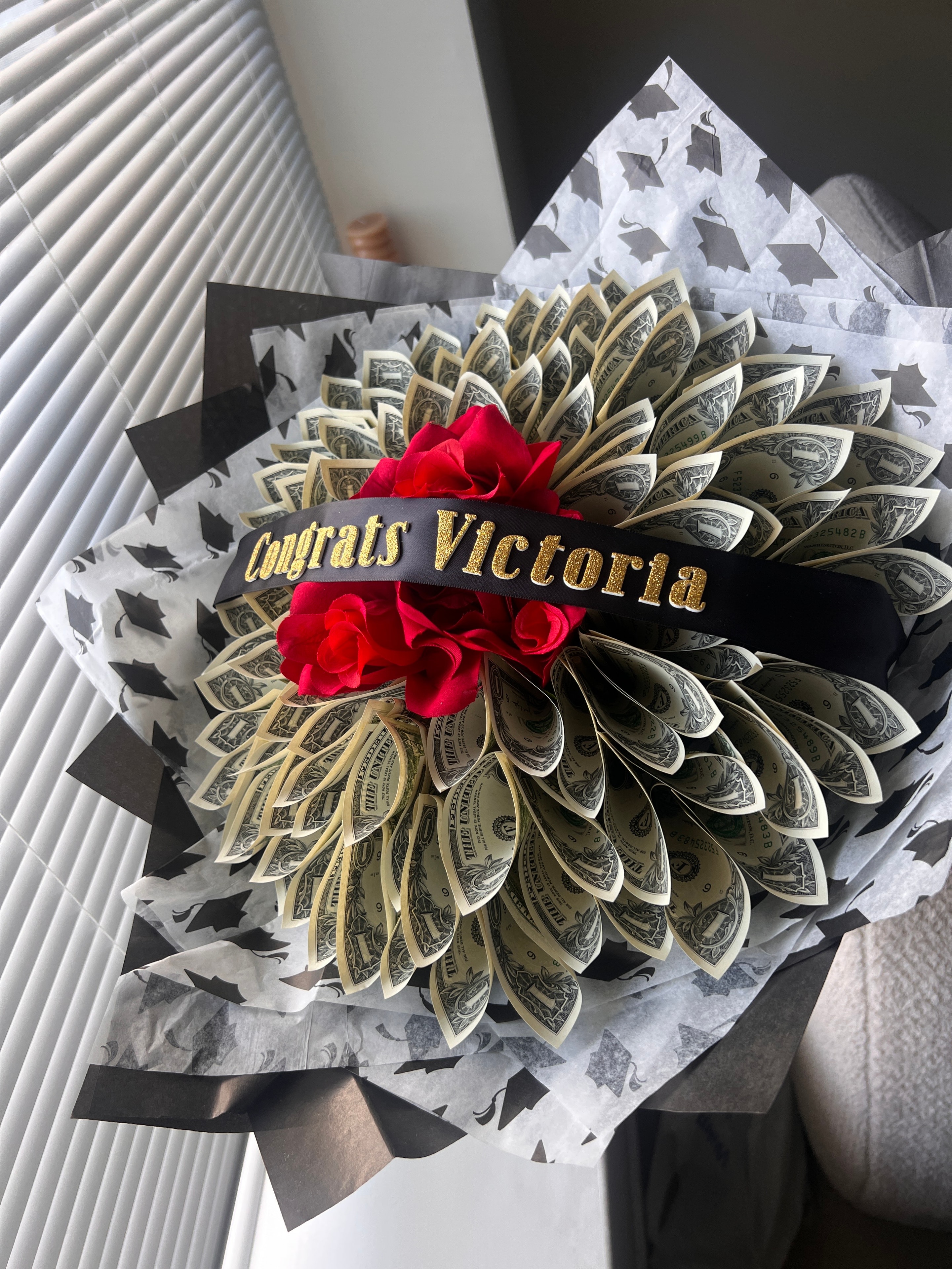 Custom money bouquet with dollar bills, red roses, and personalized topper